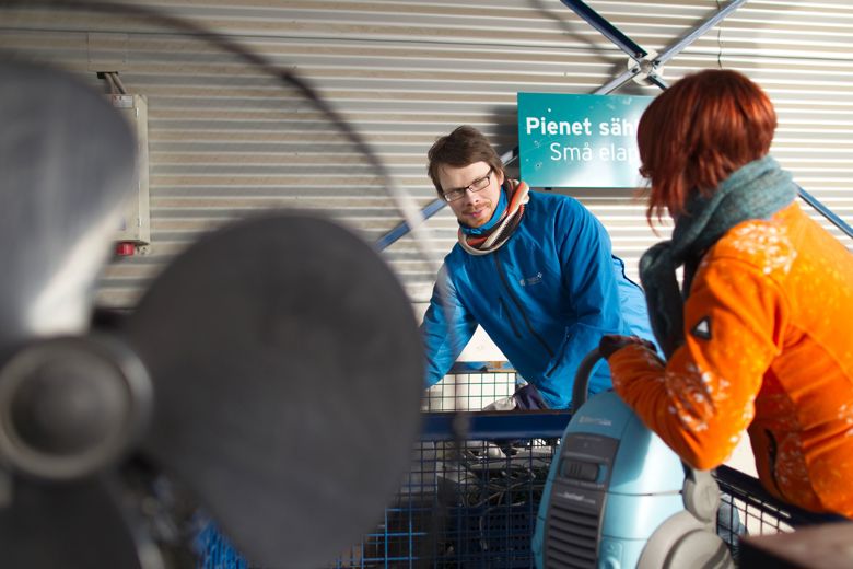 Mies ja nainen pienten sähkölaitteiden keräyspisteellä.